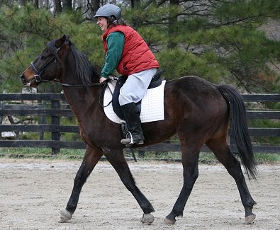 The rider is in a two point seat with her weight down in her heels.